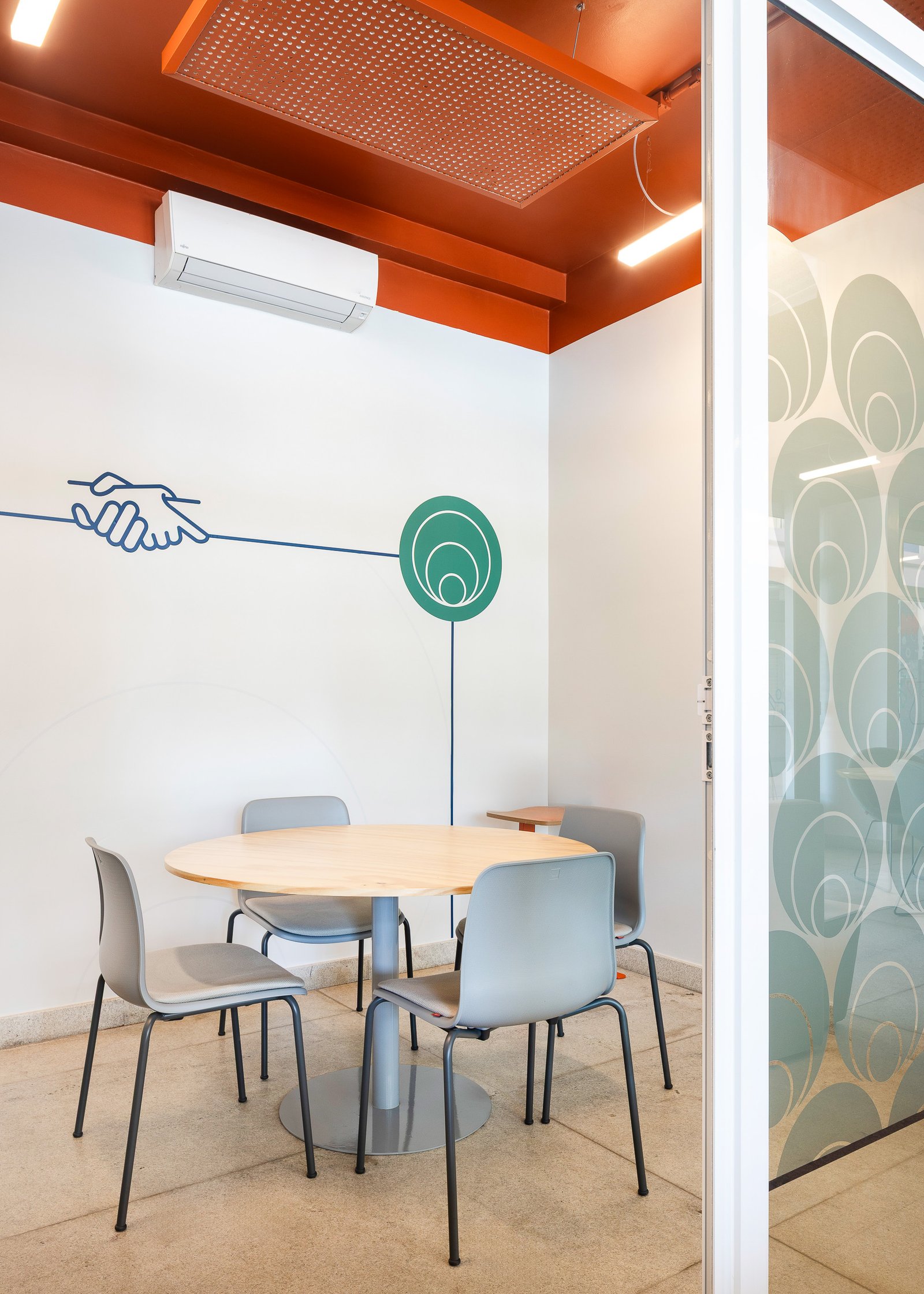 Sala fechada de atendimento individual com mural de aperto de mãos