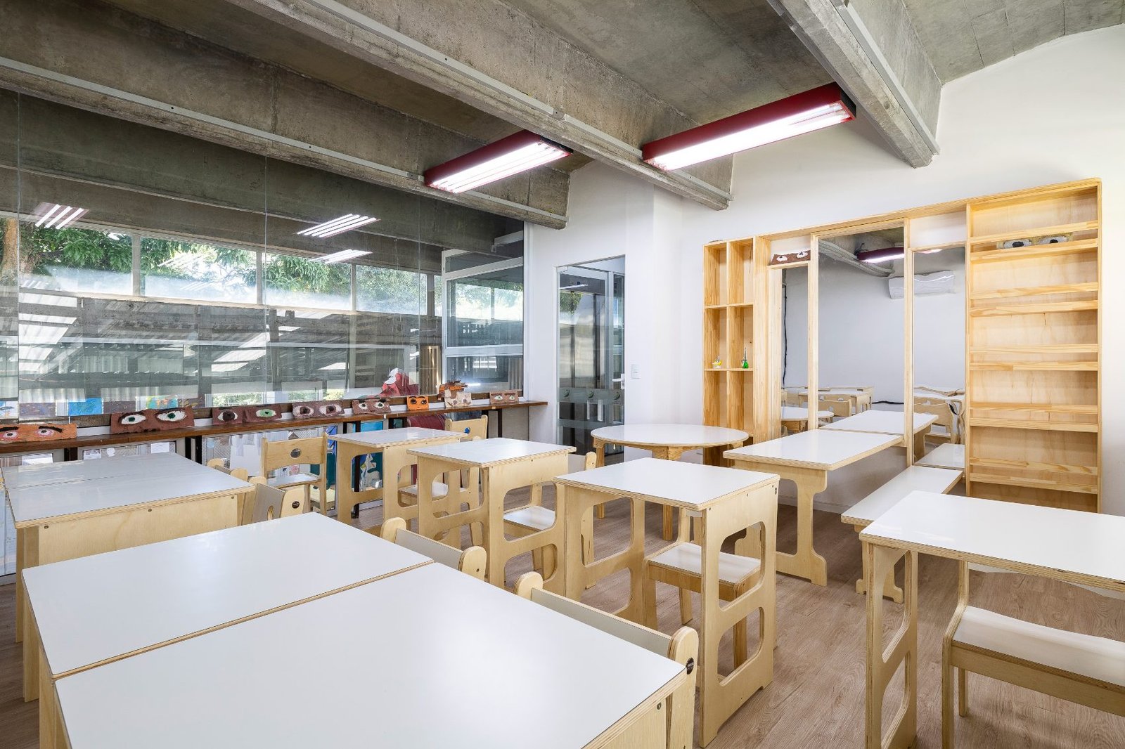 Sala de aula clara com mobiliário de madeira