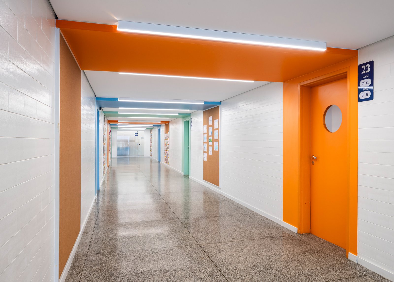 Sala ampliável com parede divisória retrátil, carteiras azuis e laranja