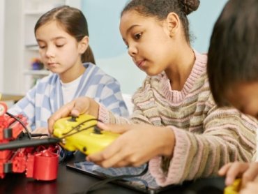 Sala maker nas escolas com crianças manipulando materiais e equipamentos em uma atividade prática de criação e aprendizagem colaborativa.