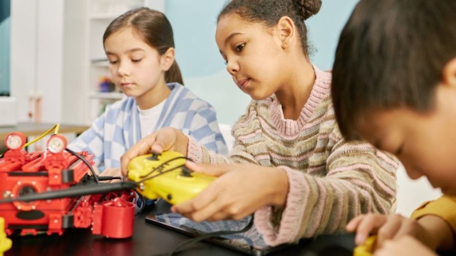 Sala maker nas escolas com crianças manipulando materiais e equipamentos em uma atividade prática de criação e aprendizagem colaborativa.