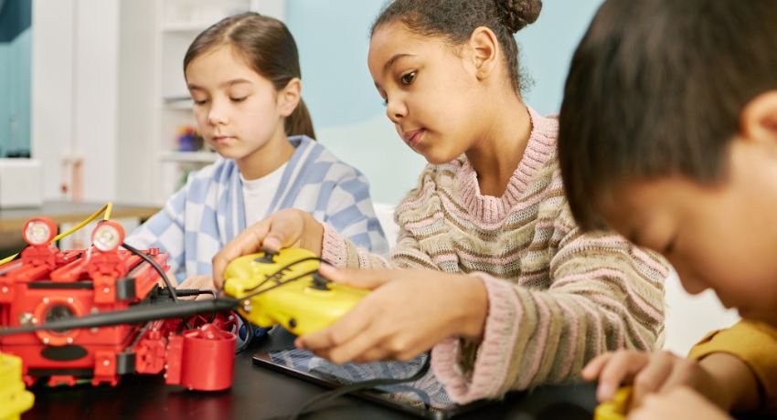 Sala maker nas escolas com crianças manipulando materiais e equipamentos em uma atividade prática de criação e aprendizagem colaborativa.